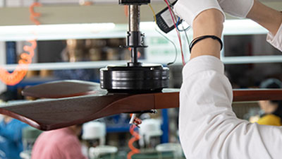 Technician performing balance calibration on a fully assembled VANYE ceiling fan to ensure stable and vibration-free operation.